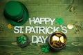 Happy St Patricks Day wooden latters with shamrocks Leprachaun hat on wooden background