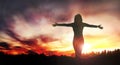 Happy standing woman looks at the sunset with open hands Royalty Free Stock Photo