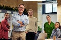 Happy startup team. Group of cheerful multiracial business people smiling at camera while standing in the modern office Royalty Free Stock Photo