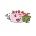 Happy strawberry cake character having a gift box Royalty Free Stock Photo