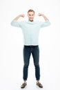 Happy strong young man standing and showing biceps