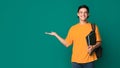 Happy student with books holding something on palm Royalty Free Stock Photo