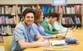 Happy student boy with books writing in library Royalty Free Stock Photo