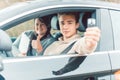 Happy student of driving school showing car keys