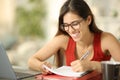 Happy student with eyeglasses taking notes at home Royalty Free Stock Photo