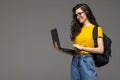 Happy student girl with backpack standing and holding laptop isolated on a white background Royalty Free Stock Photo