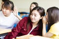 Happy student girl gossiping in classroom Royalty Free Stock Photo
