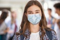 Happy student girl at high school wearing face mask