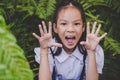 Happy student girl making a scared face in a green garden, for children hapiness and fun concept