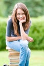 Happy student girl sitting on books Royalty Free Stock Photo