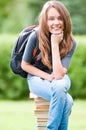 Happy student girl sitting on books Royalty Free Stock Photo