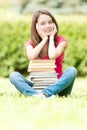 Happy student girl sitting near pile of books Royalty Free Stock Photo