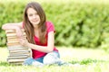 Happy student girl sitting on pile of books Royalty Free Stock Photo