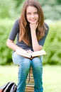 Happy student girl sitting on pile of books Royalty Free Stock Photo