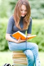 Happy student girl sitting on pile of books Royalty Free Stock Photo