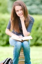 Happy student girl sitting on pile of books Royalty Free Stock Photo