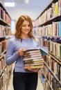 Happy student girl or woman with books in library Royalty Free Stock Photo