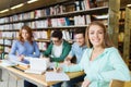 Happy student girl writing to notebook in library Royalty Free Stock Photo