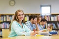 Happy student girl writing to notebook in library Royalty Free Stock Photo