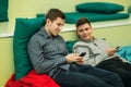 Happy student have a break in university. Have a good time while using phone , tablet and laptop. Two boys Royalty Free Stock Photo