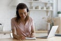 Happy student in headphones taking learning notes at laptop computer Royalty Free Stock Photo