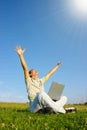 Happy student with laptop on green meadow Royalty Free Stock Photo