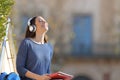 Happy student meditating listening to music in a campus Royalty Free Stock Photo