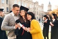 Happy student with parents after graduation ceremony