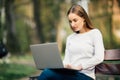 Happy student teenager girl learning with a laptop lying in a bench in an university campus Royalty Free Stock Photo