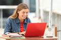 Happy student typing on a laptop in a bar Royalty Free Stock Photo