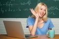 Happy student. Woman working on laptop computer over chalkboard background. Young female student ready to write exam