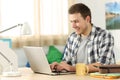 Happy student writing in a laptop in his room Royalty Free Stock Photo
