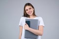 Happy Student. Young woman Student in white t-shirt holding laptop and laptop, isolated over gray background. Student Royalty Free Stock Photo