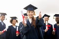 Happy students with diplomas showing thumbs up Royalty Free Stock Photo