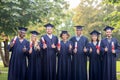 Happy students with diplomas showing thumbs up Royalty Free Stock Photo