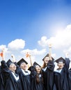 Happy  students in graduation gowns holding diplomas on cloud background Royalty Free Stock Photo