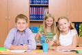 Happy students sitting at their desks in the classroom Royalty Free Stock Photo