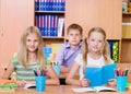 Happy students sitting at their desks in the classroom Royalty Free Stock Photo