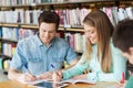 Happy students writing to notebooks in library Royalty Free Stock Photo