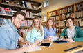 Happy students writing to notebooks in library Royalty Free Stock Photo