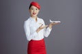 happy stylish asian female air hostess isolated on gray Royalty Free Stock Photo