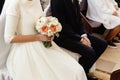 Happy stylish bride and elegant groom sitting at catholic wedding ceremony at church Royalty Free Stock Photo