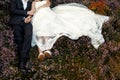 Happy stylish bride and groom embracing in sun light lying in he Royalty Free Stock Photo