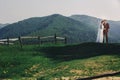 Happy stylish bride and groom running and having fun in mountains on summer sunny day. gorgeous newlywed couple laughing, true