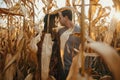 Happy stylish couple embracing in autumn corn field in warm sunset light Royalty Free Stock Photo