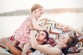 Happy stylish family relaxing in hammock on summer vacation in evening sun light on the beach. hipster couple with child resting Royalty Free Stock Photo