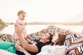 Happy stylish family relaxing in hammock on summer vacation in evening sun light on the beach. hipster couple with child resting Royalty Free Stock Photo