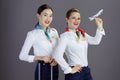 happy stylish female air hostesses isolated on gray background Royalty Free Stock Photo