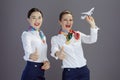 happy stylish female air hostesses isolated on grey background Royalty Free Stock Photo