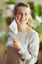 Happy stylish female in grey blouse taking off ffp2 mask